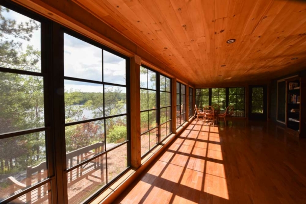 Sun room with a view of the lake and outside bench